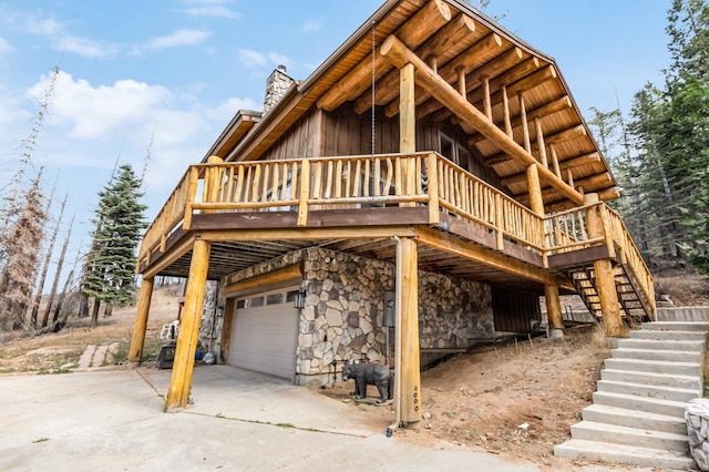 39801 Woody Ln, Shaver Lake, CA 93664 - view of front facade featuring stairway, stone siding, an attached garage, and a wooden deck