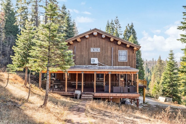 39801 Woody Ln, Shaver Lake, CA 93664 - view of front facade with covered porch, a metal roof, and a view of trees