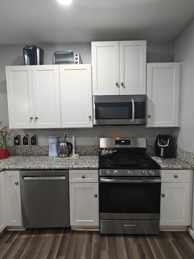 375 W Fir Ave, Pinedale, CA 93650 - kitchen featuring appliances with stainless steel finishes, white cabinets, dark wood-style flooring, and light stone countertops