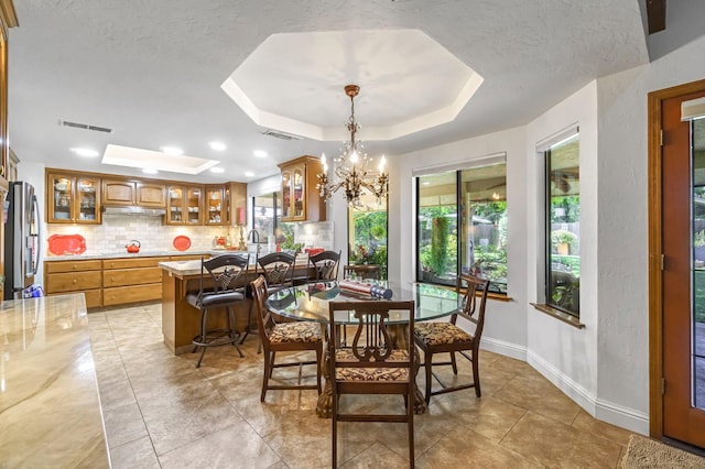 1721 W Wrenwood Ave, Fresno, CA 93711 - dining room with a raised ceiling, a chandelier, a textured ceiling, and light tile patterned floors