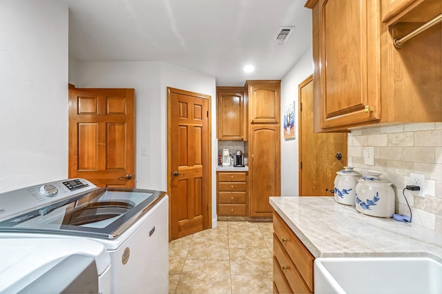 1721 W Wrenwood Ave, Fresno, CA 93711 - washroom featuring cabinet space, washer and dryer, and light tile patterned floors