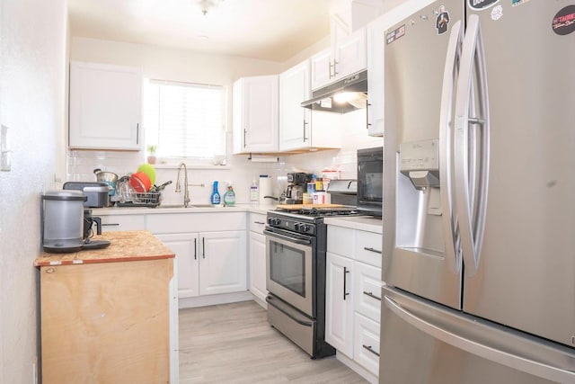1413 W Fountain Way, Fresno, CA 93705 - kitchen featuring appliances with stainless steel finishes, under cabinet range hood, decorative backsplash, and white cabinetry