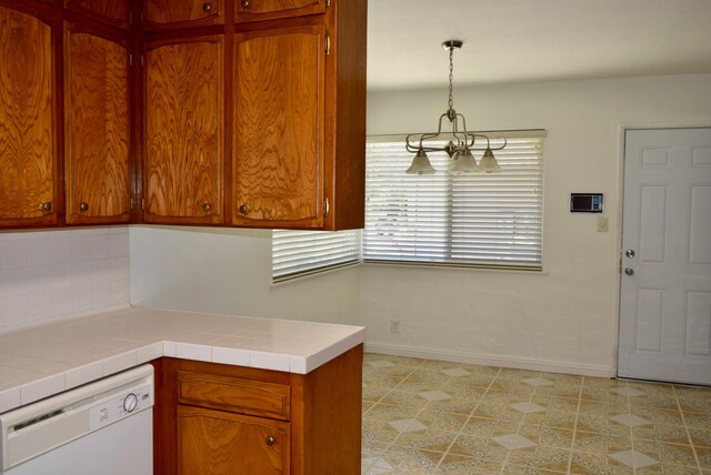 6061 N 9th St, Fresno, CA 93710 - kitchen featuring white dishwasher, backsplash, brown cabinetry, and light floors