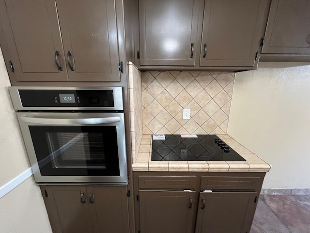 4308 N Cedar Ave, Fresno, CA 93726 - kitchen with stainless steel oven, black electric stovetop, decorative backsplash, tile countertops, and gray cabinets