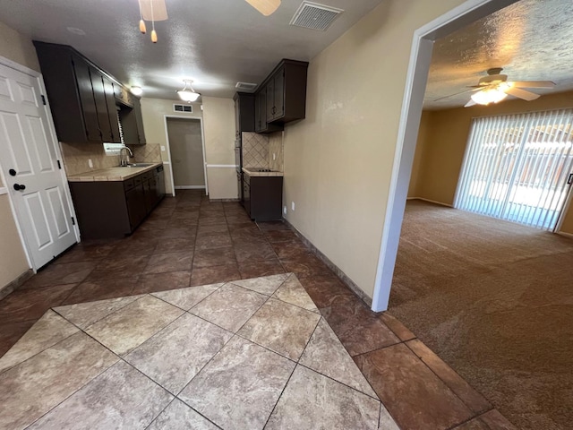 4308 N Cedar Ave, Fresno, CA 93726 - kitchen featuring ceiling fan, light countertops, decorative backsplash, and dark tile patterned flooring