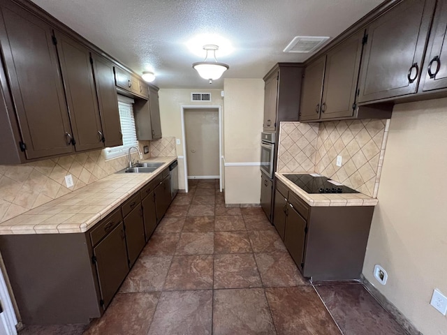 4308 N Cedar Ave, Fresno, CA 93726 - kitchen with stainless steel appliances, tile counters, decorative backsplash, and a textured ceiling