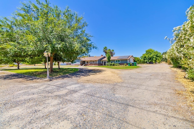 6589 N De Wolf Ave N, Clovis, CA 93619 - ranch-style house with curved driveway and solar panels