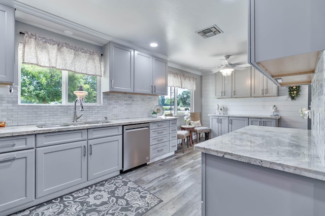 6589 N De Wolf Ave N, Clovis, CA 93619 - kitchen with stainless steel dishwasher, ceiling fan, tasteful backsplash, light wood-style floors, and light stone counters