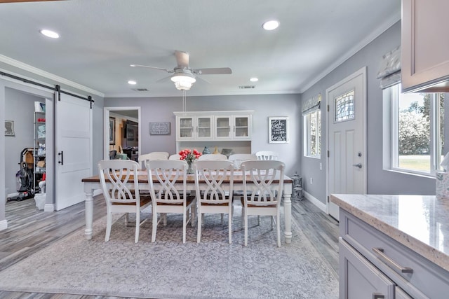 6589 N De Wolf Ave N, Clovis, CA 93619 - dining space with crown molding, a barn door, light wood-style flooring, a ceiling fan, and recessed lighting