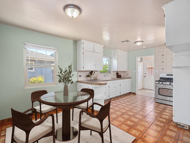 2845 N Adoline Ave, Fresno, CA 93705 - kitchen featuring gas stove, decorative backsplash, white cabinetry, and light countertops