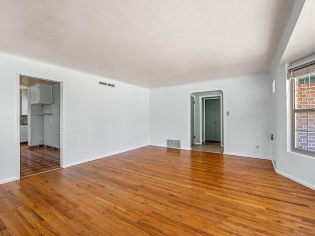 2845 N Adoline Ave, Fresno, CA 93705 - empty room with light wood finished floors and arched walkways