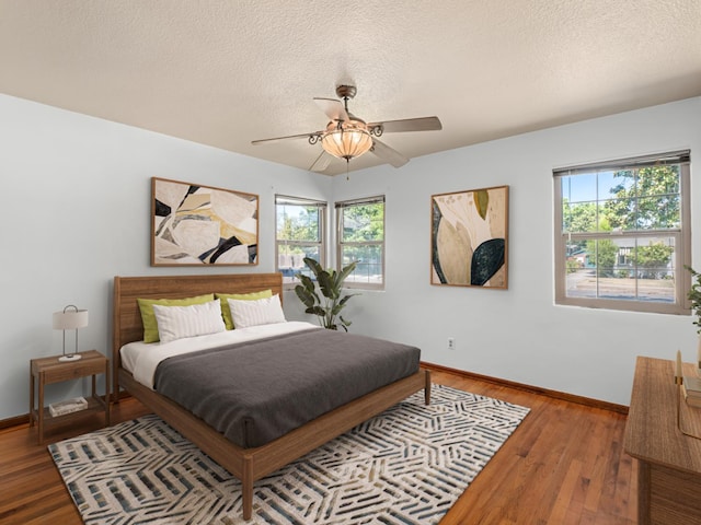 2845 N Adoline Ave, Fresno, CA 93705 - bedroom featuring multiple windows, wood finished floors, a textured ceiling, and ceiling fan