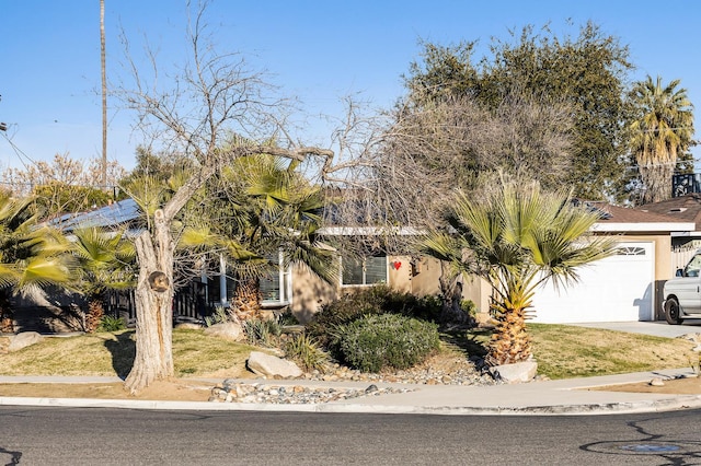 4404 N Eddy Ave, Fresno, CA 93727 - obstructed view of property featuring an attached garage, driveway, and stucco siding