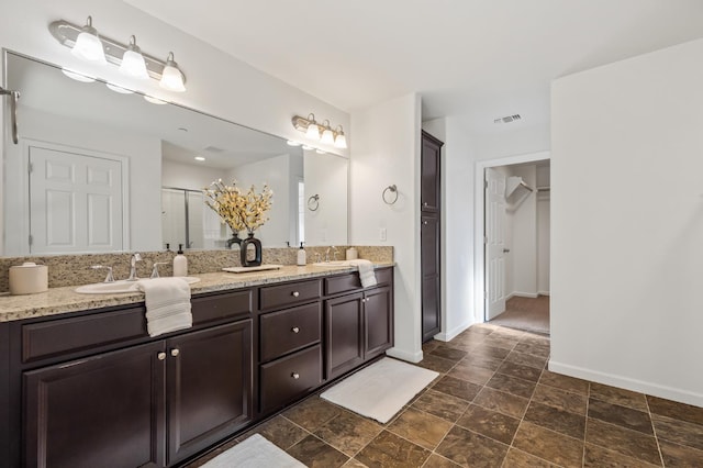 7141 N Shiraz Ave, Fresno, CA 93722 - bathroom with double vanity, a closet, a shower stall, and stone finish floors