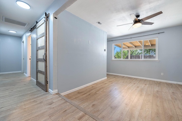 3318 Stanford Ave, Clovis, CA 93611 - empty room featuring a barn door, wood finished floors, and a ceiling fan