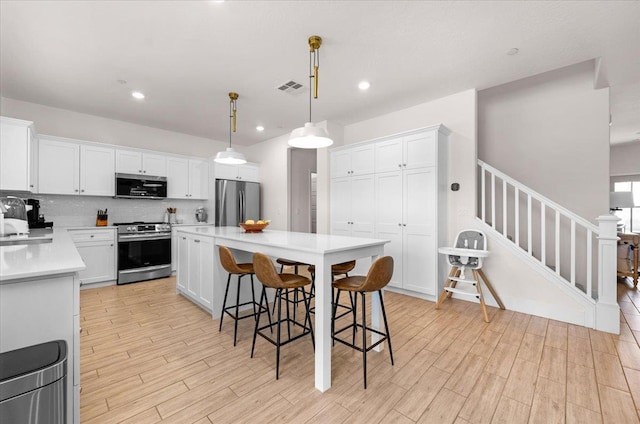 859 Windmill Ave, Clovis, CA 93619 - kitchen with stainless steel appliances, light countertops, white cabinetry, a kitchen island, and recessed lighting