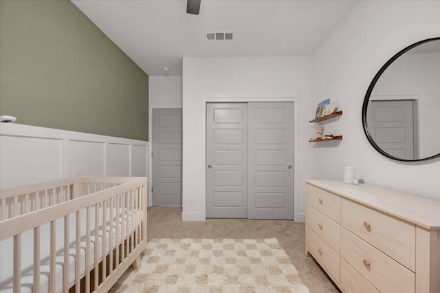 859 Windmill Ave, Clovis, CA 93619 - bedroom with a crib, a closet, light colored carpet, a wainscoted wall, and a decorative wall