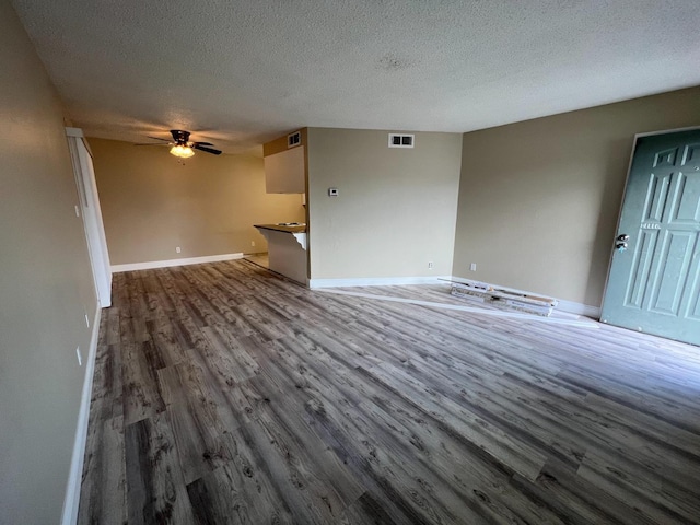 1205 F St, Reedley, CA 93654 - unfurnished living room with wood finished floors, a textured ceiling, and ceiling fan