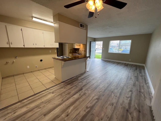 1205 F St, Reedley, CA 93654 - kitchen with a textured ceiling, dark countertops, wood finished floors, open floor plan, and ceiling fan