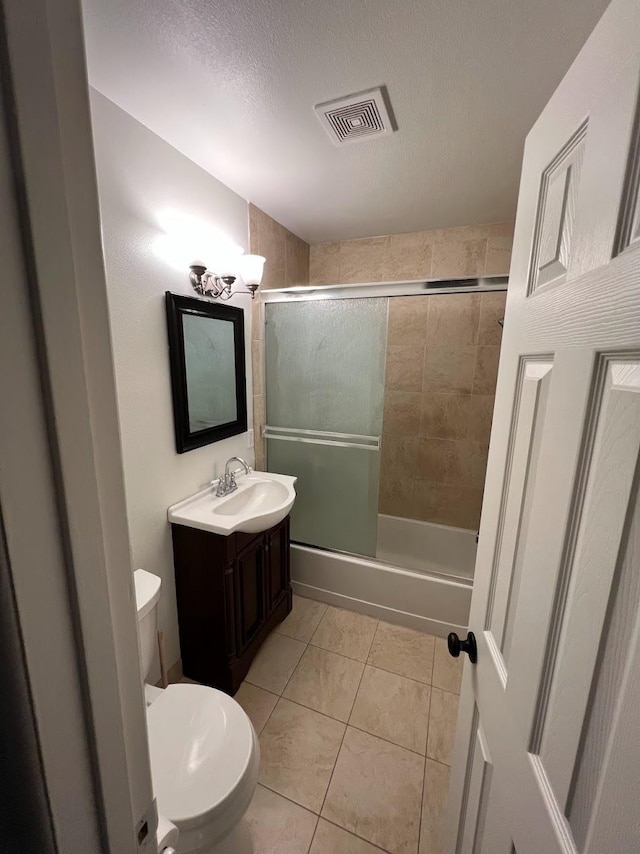 1205 F St, Reedley, CA 93654 - bathroom featuring vanity, combined bath / shower with glass door, tile patterned flooring, and a textured ceiling
