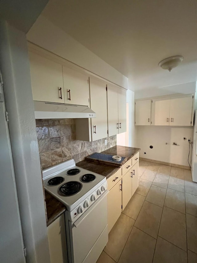 1205 F St, Reedley, CA 93654 - kitchen with electric range, under cabinet range hood, dark countertops, backsplash, and light tile patterned floors