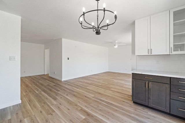 19730 Brightwood Rd, Madera, CA 93638 - kitchen with a chandelier, light wood finished floors, white cabinetry, tasteful backsplash, and open floor plan