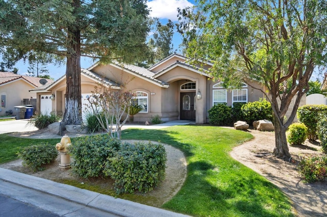 122 E Loop, Madera, CA 93637 - single story home with stucco siding, a front yard, a garage, a tile roof, and driveway