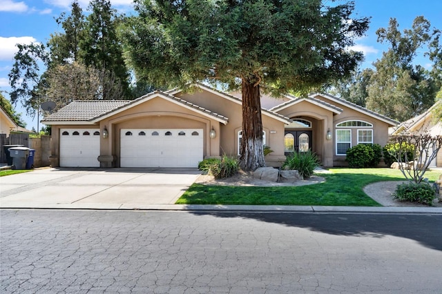 122 E Loop, Madera, CA 93637 - view of front of property featuring stucco siding, driveway, a garage, and a tile roof