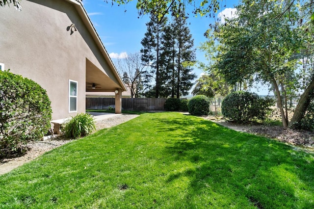 122 E Loop, Madera, CA 93637 - fenced backyard with ceiling fan and a patio area