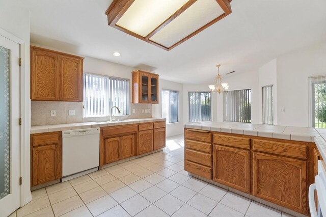 122 E Loop, Madera, CA 93637 - kitchen featuring white dishwasher, brown cabinets, backsplash, a chandelier, and recessed lighting