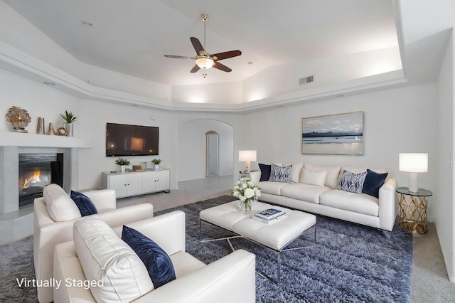 122 E Loop, Madera, CA 93637 - living room featuring arched walkways, ceiling fan, a glass covered fireplace, a raised ceiling, and lofted ceiling