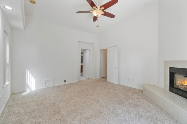 122 E Loop, Madera, CA 93637 - unfurnished living room featuring a towering ceiling, carpet flooring, a tiled fireplace, ceiling fan, and recessed lighting