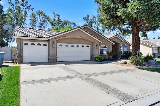 122 E Loop, Madera, CA 93637 - ranch-style house with a tile roof, stucco siding, driveway, and a garage
