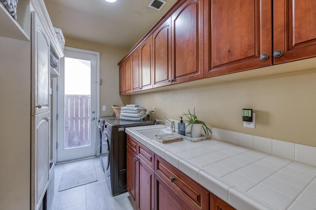3016 San Gabriel Ave, Clovis, CA 93619 - laundry area featuring washing machine and clothes dryer, cabinet space, and light tile patterned flooring