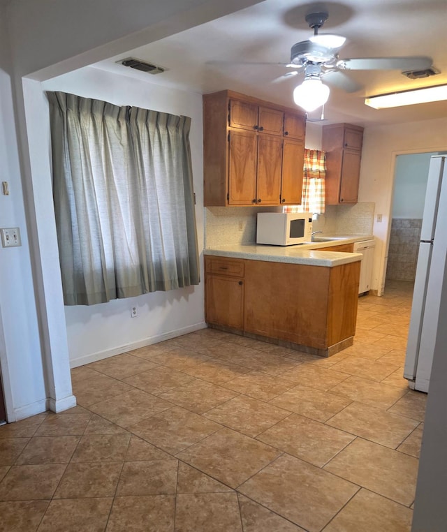 5525 S Fig Ave, Fresno, CA 93706 - kitchen featuring white appliances, ceiling fan, a peninsula, light countertops, and brown cabinets