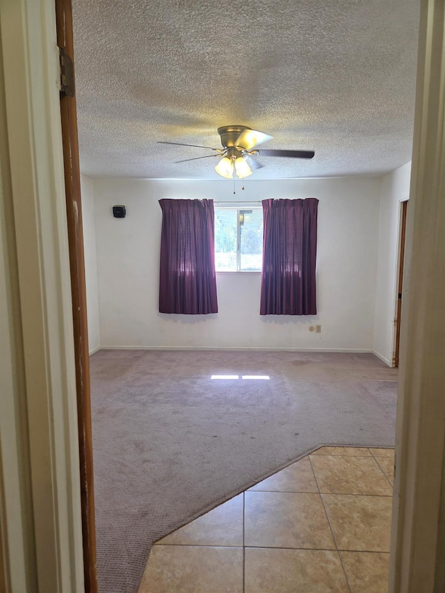 5525 S Fig Ave, Fresno, CA 93706 - spare room featuring light colored carpet, a ceiling fan, a textured ceiling, and light tile patterned floors