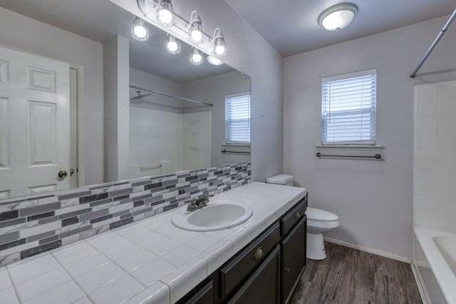 4665 W Yale Ave, Fresno, CA 93722 - full bathroom with vanity, wood finished floors, backsplash, and shower / bathtub combination