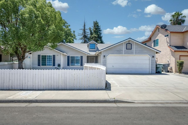 4665 W Yale Ave, Fresno, CA 93722 - view of front of house featuring a garage, concrete driveway, and a fenced front yard
