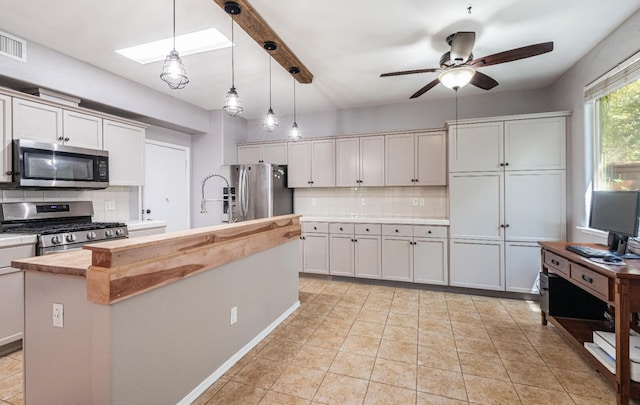 1734 Glen Oban Ln, Clovis, CA 93619 - kitchen featuring appliances with stainless steel finishes, butcher block counters, backsplash, a ceiling fan, and decorative light fixtures