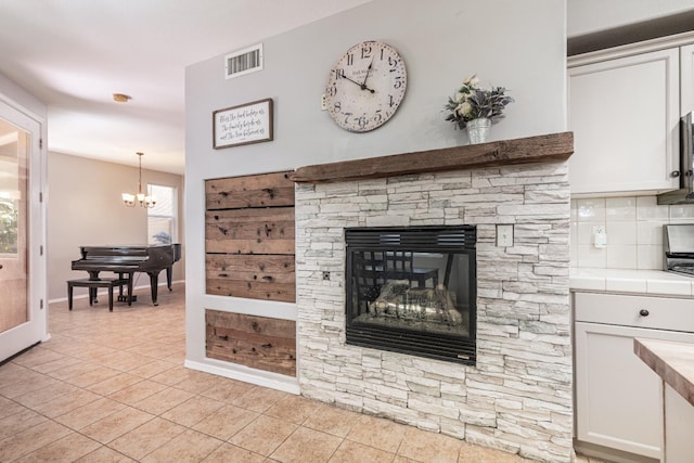1734 Glen Oban Ln, Clovis, CA 93619 - living area with a chandelier, light tile patterned flooring, plenty of natural light, and a stone fireplace