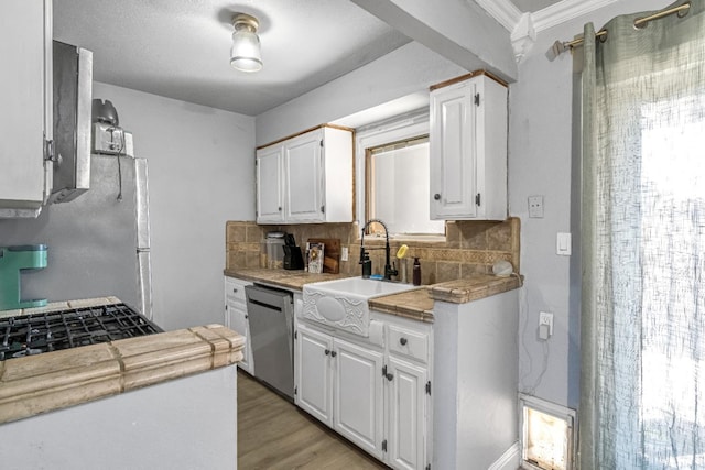 5098 E Ashlan Ave Unit 116, Fresno, CA 93727 - kitchen with appliances with stainless steel finishes, white cabinets, tasteful backsplash, light wood-type flooring, and tile countertops