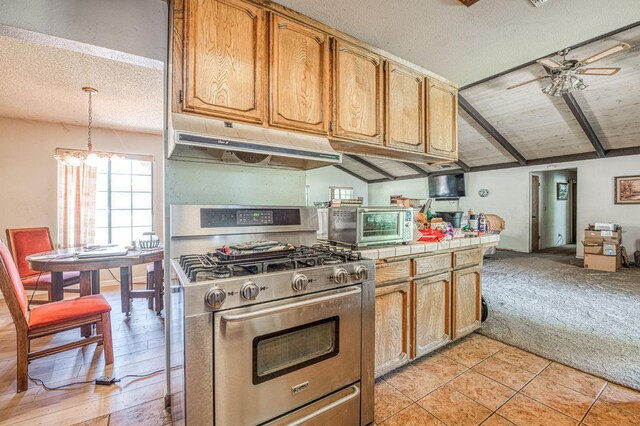 7815 N Sanders Ave, Clovis, CA 93619 - kitchen with stainless steel gas range, under cabinet range hood, tile countertops, ceiling fan, and a textured ceiling