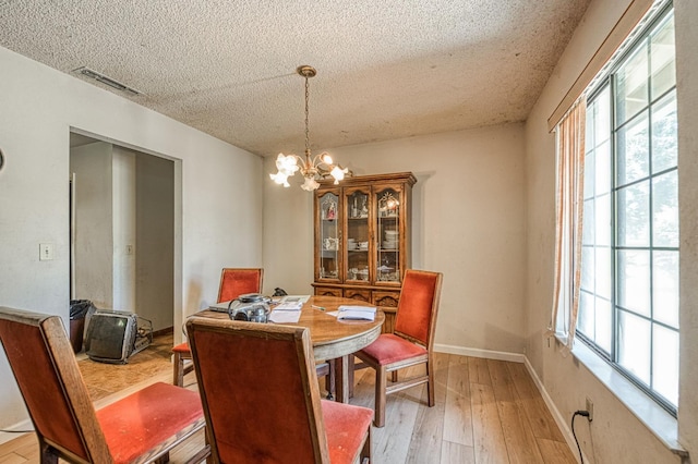 7815 N Sanders Ave, Clovis, CA 93619 - dining room featuring a textured ceiling, light wood-style flooring, and a chandelier
