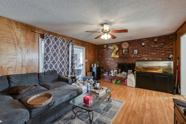786 E Barstow Ave, Fresno, CA 93710 - living area with ceiling fan, a textured ceiling, wood finished floors, a fireplace, and wood walls