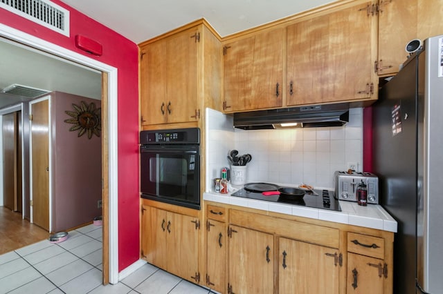 786 E Barstow Ave, Fresno, CA 93710 - kitchen featuring black appliances, under cabinet range hood, tile countertops, and decorative backsplash