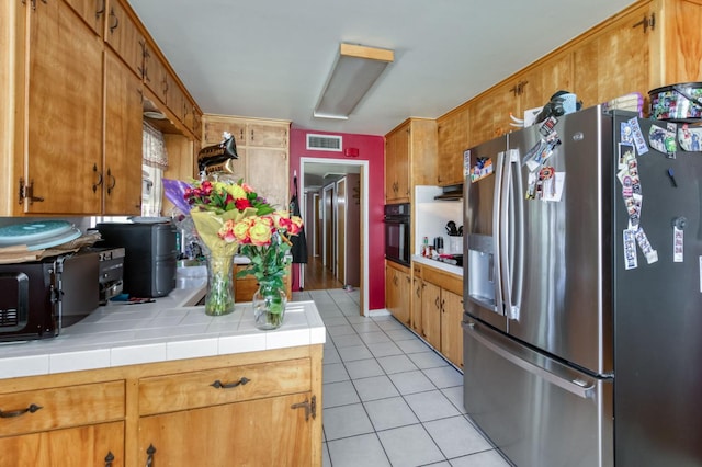 786 E Barstow Ave, Fresno, CA 93710 - kitchen with stainless steel refrigerator with ice dispenser, oven, light tile patterned floors, and brown cabinets