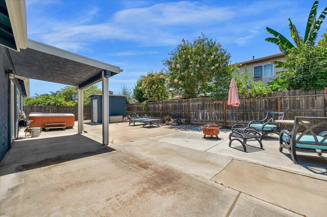 3673 N Denali Ave, Fresno, CA 93727 - fenced backyard with a hot tub, a patio, an outdoor fire pit, and a storage shed