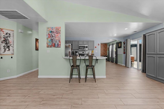 3673 N Denali Ave, Fresno, CA 93727 - kitchen with appliances with stainless steel finishes, gray cabinets, wood tiled floors, a peninsula, and recessed lighting