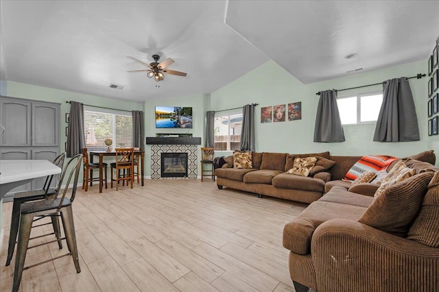 3673 N Denali Ave, Fresno, CA 93727 - living room with lofted ceiling, light wood-style flooring, ceiling fan, and a glass covered fireplace