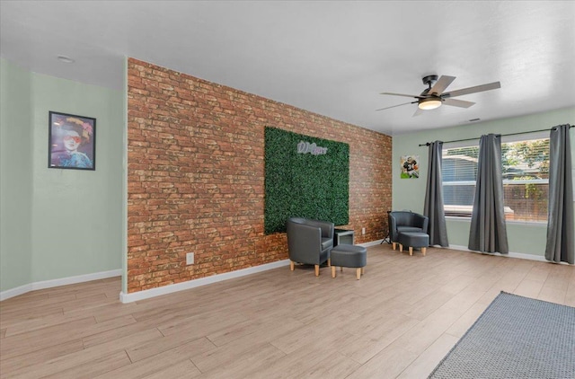 3673 N Denali Ave, Fresno, CA 93727 - living area featuring a ceiling fan, brick wall, and light wood-style flooring